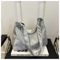 Detail of silver metallic hobo bag with marble texture finish on white books - No Pendant / Silver
