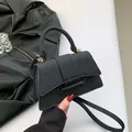 Elegante borsa a tracolla nera intrecciata con dettagli dorati e manico superiore - Nero