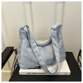 Close-up of light blue hobo tote bag with silver metal ring and soft textured fabric - No Pendant / Blue