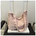 Detail of soft pink large capacity tote bag with adjustable strap on a leather chair - No Pendant / Pink