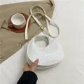 White woven faux leather crescent bag with adjustable strap and gold-tone hardware - White