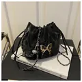 Close-up of black drawstring bucket bag with silver butterfly pendant and metal chain - Black Without Pendant