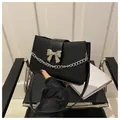 Classic black leather crossbody bag with silver bow detail and stylish chain strap - Black