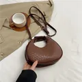 Brown woven crescent bag with adjustable shoulder strap and gold hardware accents - Coffee