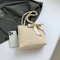 Chic cream straw tote bag with braided rope handles and heart pattern ribbon detail - Off White