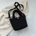 Bolso tipo cubo negro texturizado con asa de felpa y correa de tela ajustable - Negro