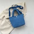 Bolso cubo de pana azul con asa superior y correa de hombro ajustable para uso casual - Azul
