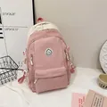 Detail eines rosa-beigen Canvas-Rucksacks mit kreisförmiger Smiley-Stickerei-Applikation - Rosa