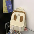 Cream student backpack with brown bunny ears decoration and buckle front pocket design - White