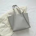 Bolso tote gris de gran capacidad en cuero mate con costuras decorativas sobre fondo - Gris