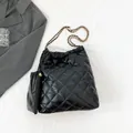 Black quilted drawstring tote bag in glossy finish with gold chain strap and pouch - Black