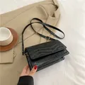 Elegante schwarze Umhängetasche mit Krokodilmuster, goldener Hardware und Schulterriemen - Schwarz