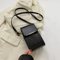 Minimalistische schwarze Umhängetasche aus mattem Leder mit goldener Metallverzierung - Schwarz