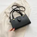 Klassische schwarze Handtasche aus Leder mit Litschi-Maserung und Goldbeschlägen - Schwarz