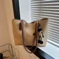 Detalle del bolso tote beige con correas marrones y un charm de oveja en ventana - 37*25.5*13 / Caqui (Con amuleto)