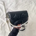Elegante borsa a tracolla nera con grande fiocco e tracolla decorativa in perle - Nero