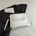 Elegante witte envelop-clutch met grijze vierkante metalen studs en een polsbandje - Wit