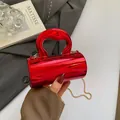 Bolso cilíndrico rojo metalizado elegante con asa ondulada y correa de cadena dorada - Rojo