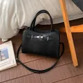 Elegant black lychee grain leather handbag with silver turn-lock and shoulder strap - Black