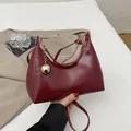 Borsa a spalla bordeaux in pelle verniciata a mezzaluna con ciondolo a sfera d'oro - Borgogna