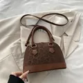 Braune Muscheltasche mit Leopardenmuster, Lederbesatz und goldenen Beschlägen - Braun