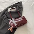 Retro burgundy pillow bag with white lace bow and dual straps on minimalist background - Red