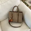 Beige canvas and brown leather crossbody tote bag with a decorative tassel charm - With Pendant / Brown
