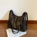 Large dark brown retro tote bag with silver buckle pocket on a white book base - Brown