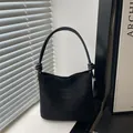Sac sous le bras minimaliste en daim noir avec poignée nouée et lettrage embossé - Noir