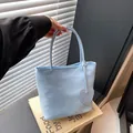 Sky blue minimalist tote bag with heart pendant accessory shown in a modern lifestyle setting - Blue