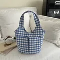 Borsa tote in tela a quadretti blu e bianchi con tasche frontali sul divano - Blu