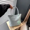 Light blue minimalist tote bag in water-resistant fabric with heart-shaped pendant detail - Green