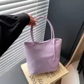 Minimalist lavender tote bag with heart charm accessory shown in a lifestyle view - Purple