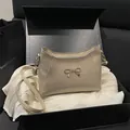 Bolso bandolera crema elegante con detalle de lazo dorado en caja de regalo lujo - Caqui