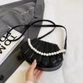 Bolso mini negro con forma de concha, textura acolchada y asa de perlas - Negro