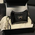 Bolso de hombro elegante en cuero brillante negro con detalle de lazo dorado en caja de regalo - Negro