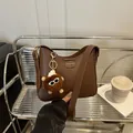 Fashion dark brown leather crescent bag with trendy plush charm and adjustable strap - Pom-pom Ornament / Brown