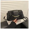 Detailansicht der schwarzen Ledertasche mit geprägtem Muster und goldenem Metallakzent - Schwarz