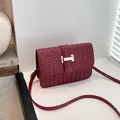 Classic burgundy woven square crossbody bag featuring a golden H-shaped metal clasp - Red
