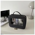 Detail of a black cross-grain toiletry bag with clear window and gold double zippers - Black