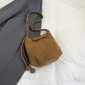 Minimalist brown suede bucket bag with decorative drawstrings and a magnetic flap - Brown