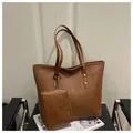 Brown faux leather tote bag with matching pouch on a chair for stylish daily commuting - Coffee