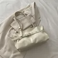 Creamy white oil wax leather shoulder bag featuring golden eyelets and modern belt detail - Off White