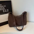 Brown hobo shoulder bag with adjustable strap and suede finish in a minimalist setting - Cocoa Brown