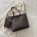 Dark brown tote bag set with matching pouch and golden rivets in a stylish urban setting - Brown