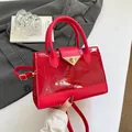 Red faux leather handbag with crocodile pattern and golden triangle buckle detail - Red