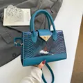 Deep blue handbag with snakeskin texture and golden triangular lock buckle strap - Blue