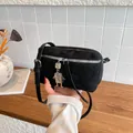 Black minimalist crossbody bag with suede finish and silver robot pendant on a wood surface - Black