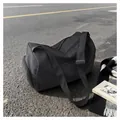Detail of waterproof nylon fitness bag with separate shoe compartment on asphalt road - Black