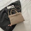 Beige faux leather crossbody tote bag with decorative rivets and buckle details - Khaki